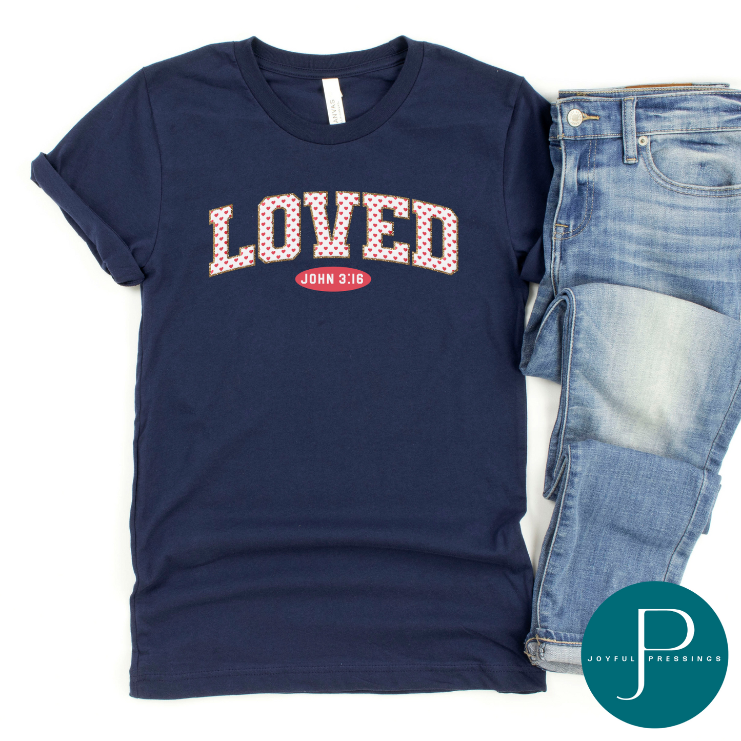 flatlay of navy blue tee with the word loved in white and adorned with pink hearts. underneath is the reference to the verse John 3:16