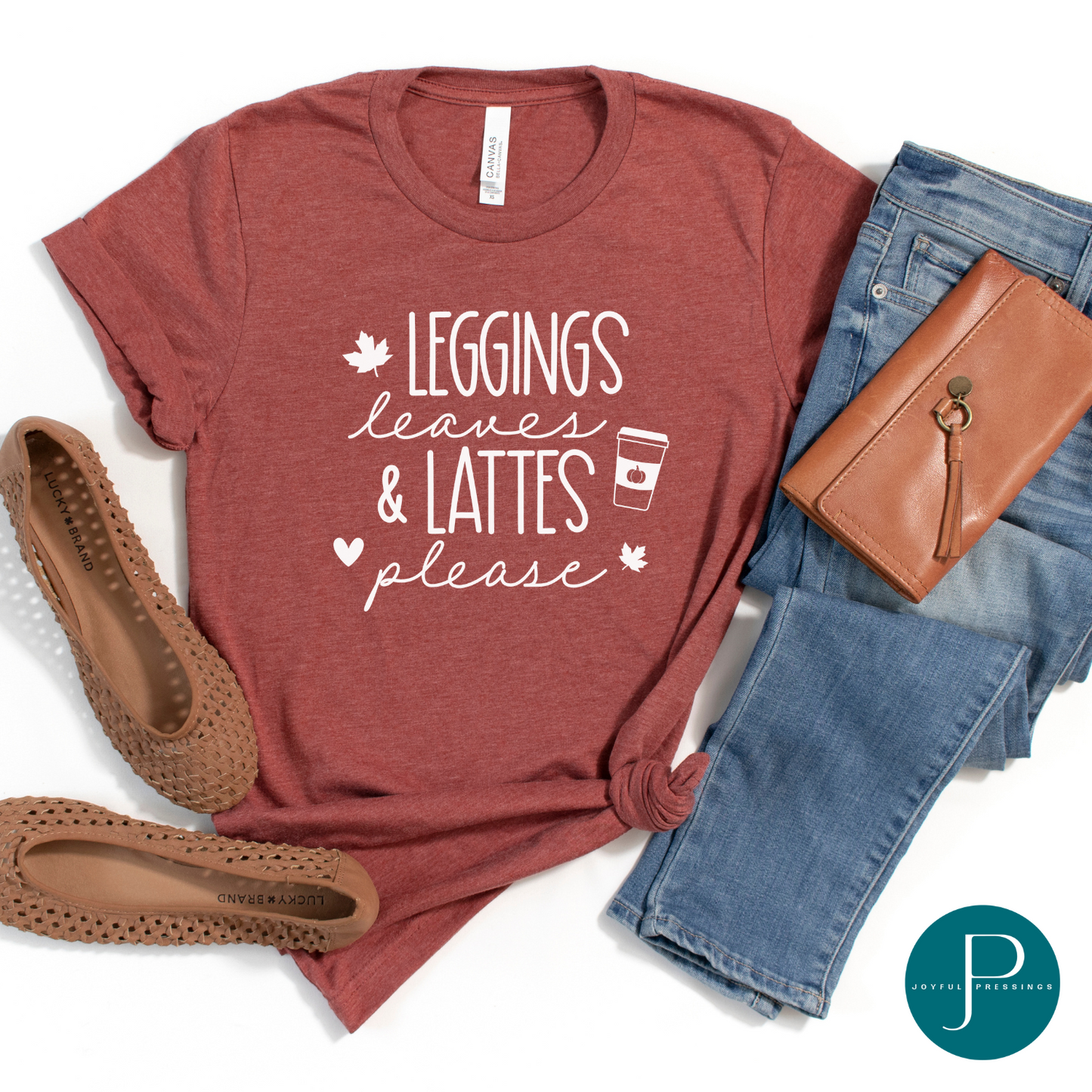 Flat-lay of heather clay t-shirt with the print Leggings Leaves & Lattes please in white.