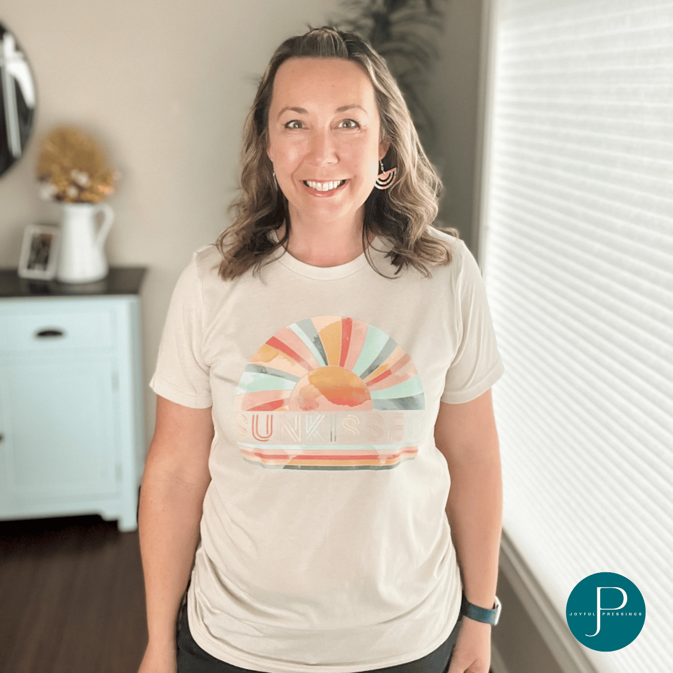 pink, teal and orange "sunkissed" print on a tan tee on a model