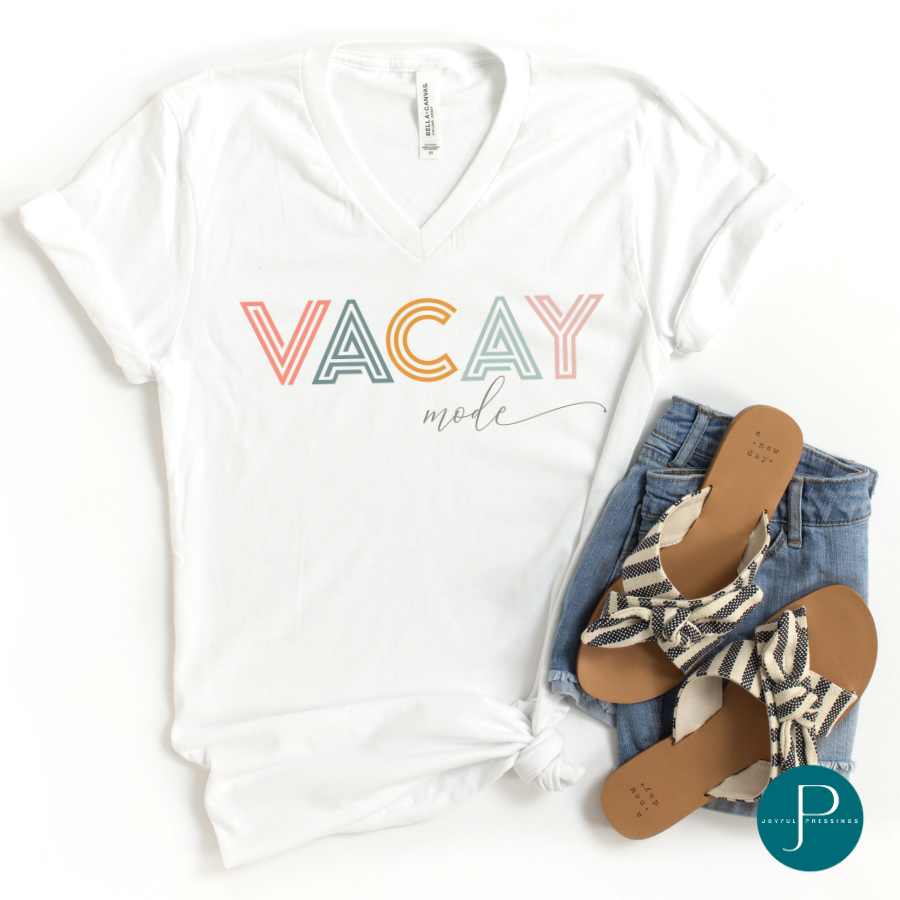 mock up of a v-neck white tee with the print "vacay mode" printed in coral, blue, orange, and pink