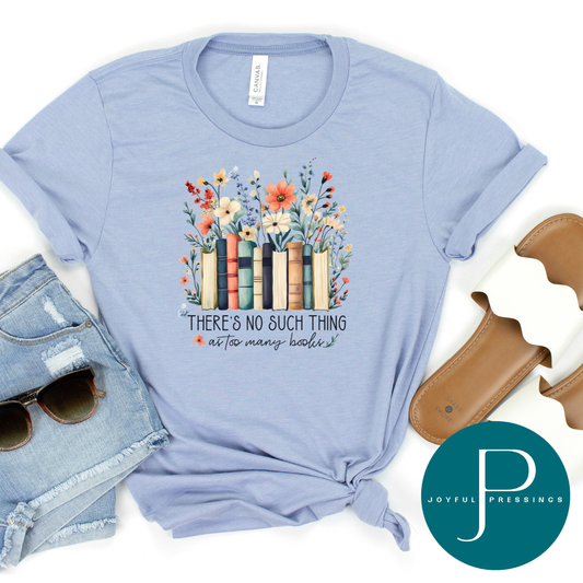 Light blue t-shirt with floral book design and text, placed on a white background with sunglasses and a brown bag.