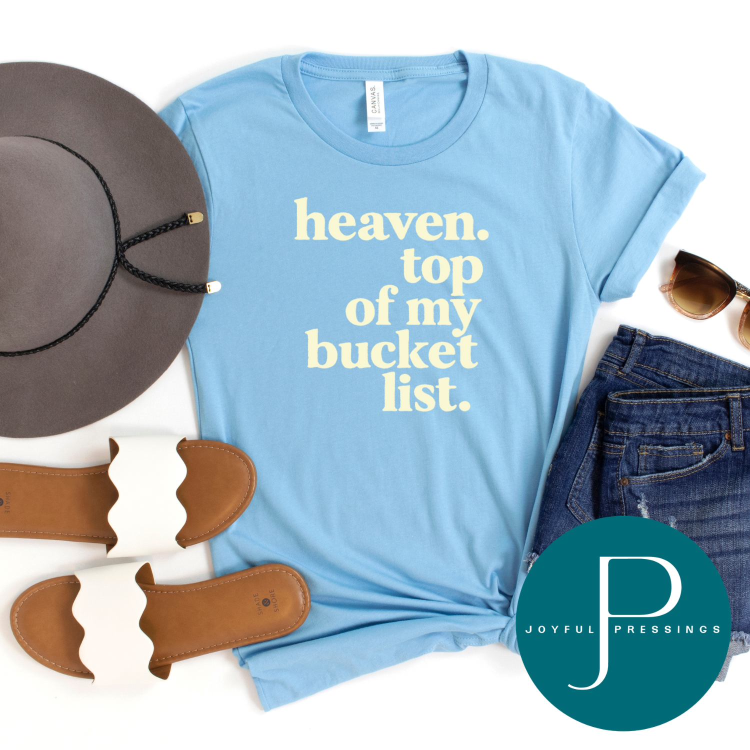 A light blue graphic t-shirt with the text 'heaven. top of my bucket list.