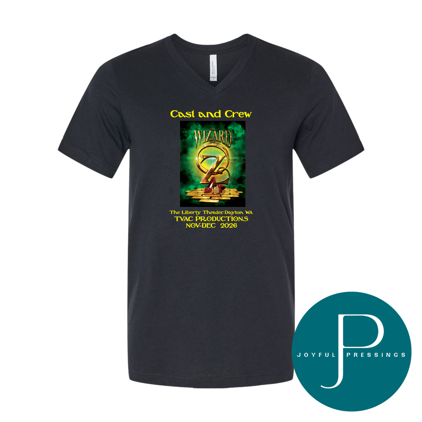 A black v-neck t-shirt featuring a green and gold graphic print for 'Cast and Crew' from The Wizard of Oz production. The shirt is displayed on a clean white background with a teal circular 'Joyful Pressings' logo overlay in the bottom right corner.
