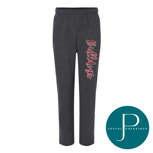 Dark gray heather sweatpants with a vertical red and white 'Bulldogs' script logo on the left leg, shown on a white background with a teal circular 'Joyful Pressings' logo in the bottom right corner.