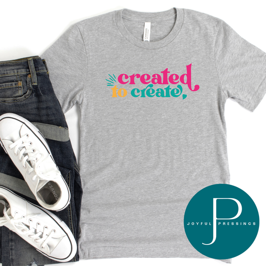Athletic heather crew neck t-shirt with the colorful phrase ‘Created to Create’ styled with jeans and white sneakers.