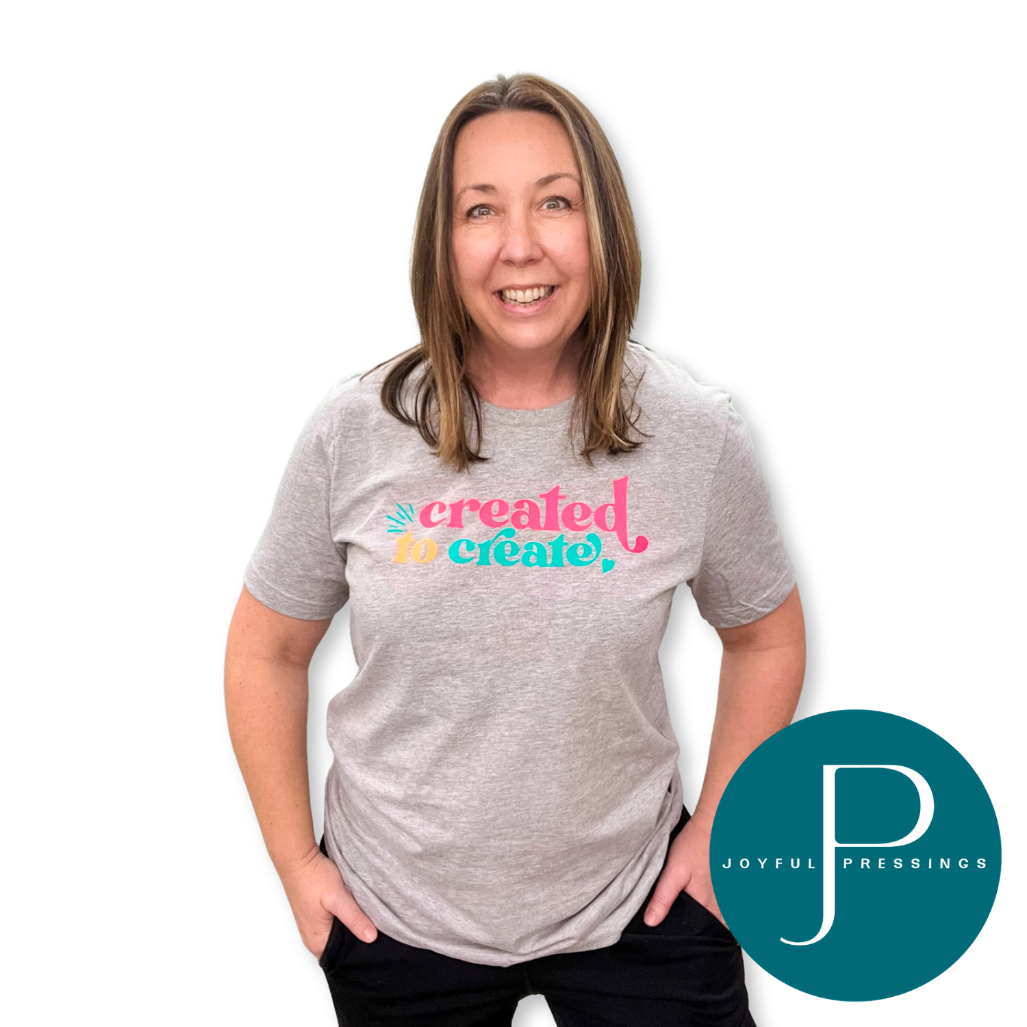 Woman wearing an athletic heather ‘Created to Create’ t-shirt, smiling with hands in pockets.