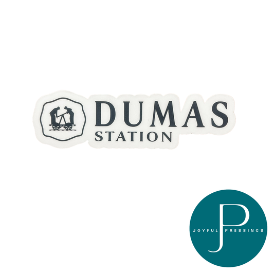 A die-cut sticker featuring the text 'DUMAS STATION' with a small illustration of a post office and train, shown on a white background. A teal circular 'JOYFUL PRESSINGS' brand logo is visible in the bottom right corner.