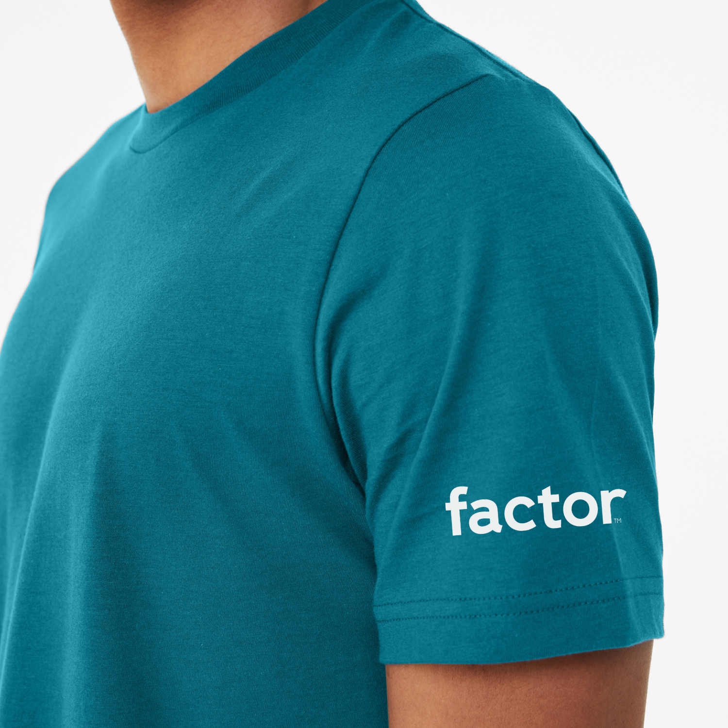 Model wearing a marine color tee with the factor logo on the sleeve.