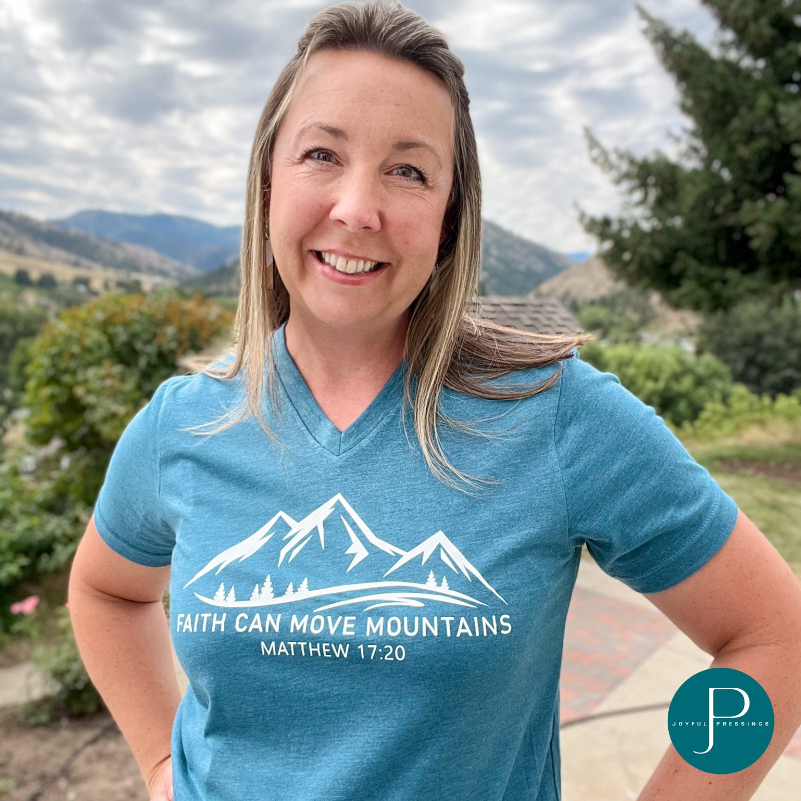 model wearing faith can move mountains print on a deep teal t-shirt