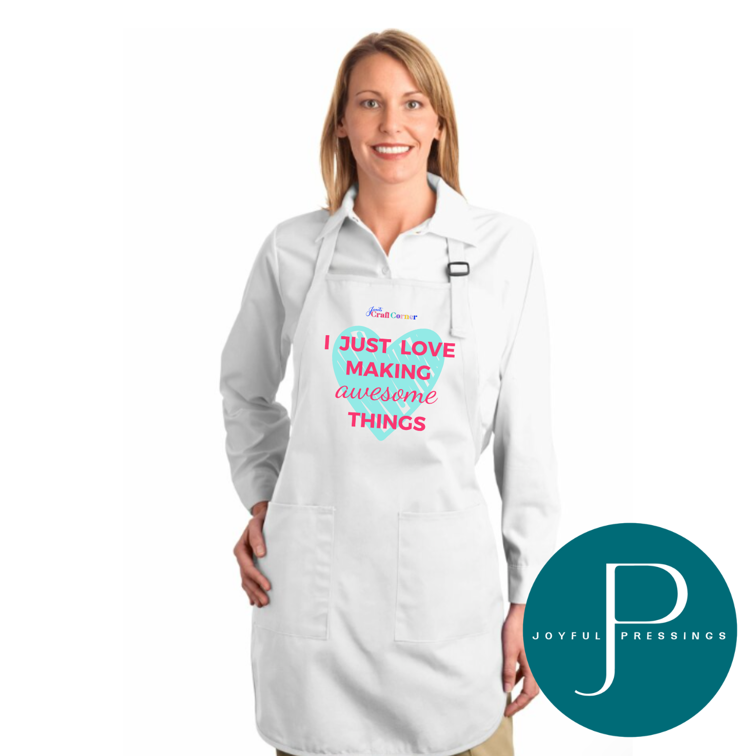 A smiling woman wearing a white apron that says “I just love making awesome things” in pink and teal lettering. The apron has two front pockets and an adjustable neck strap. Joyful Pressings logo shown in the corner.