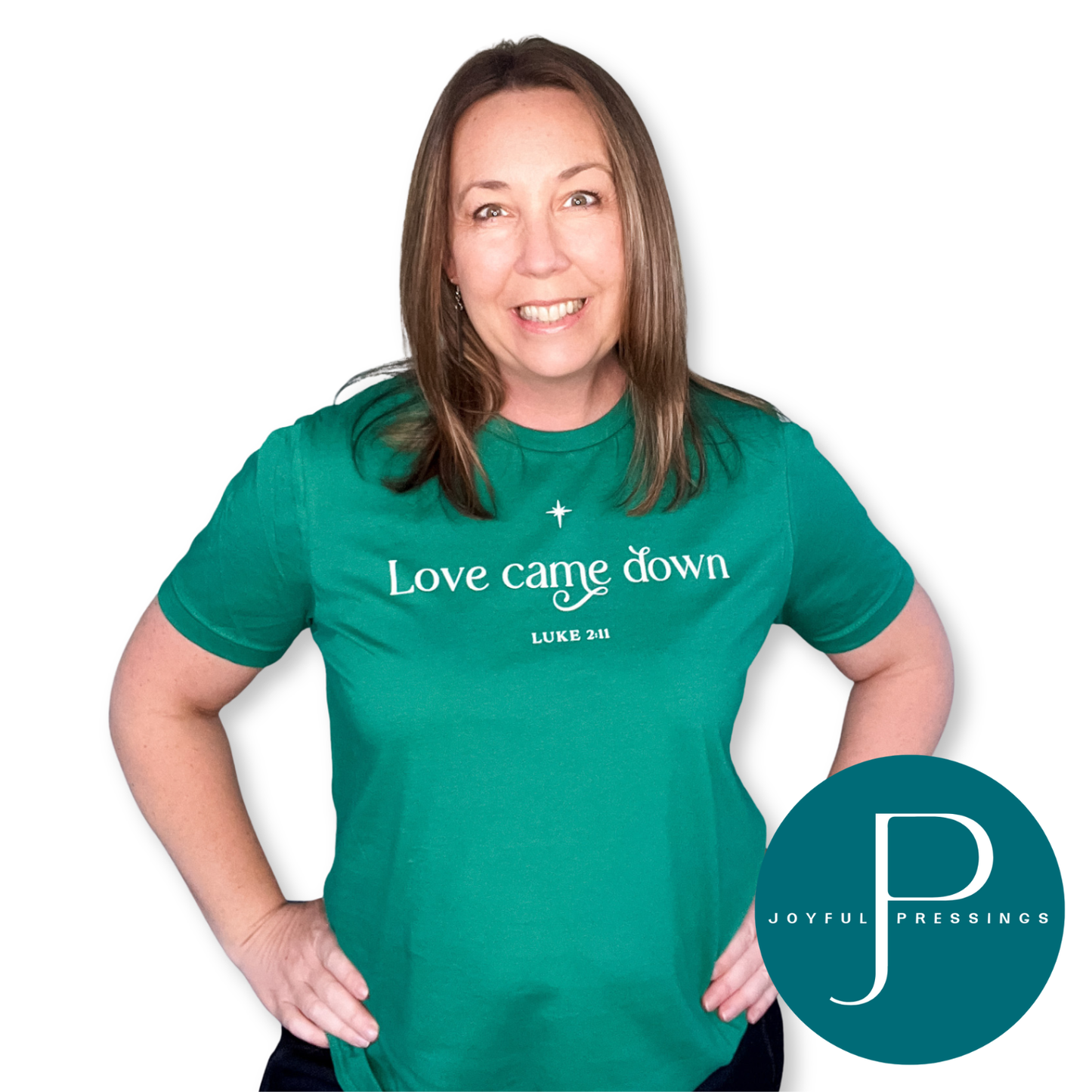 Woman wearing a Kelly green “Love Came Down” t-shirt with white lettering and star design.