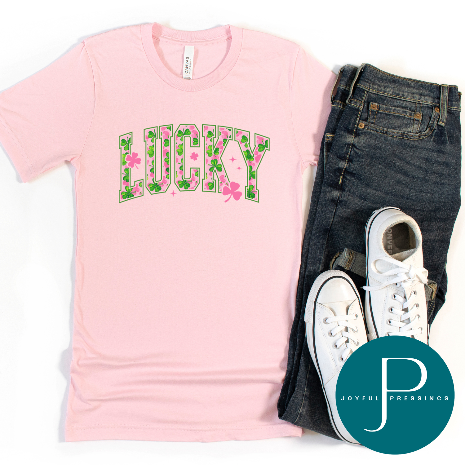 Pink t-shirt with 'LUCKY' print, jeans, and white sneakers on a white background with Joyful Pressings logo.