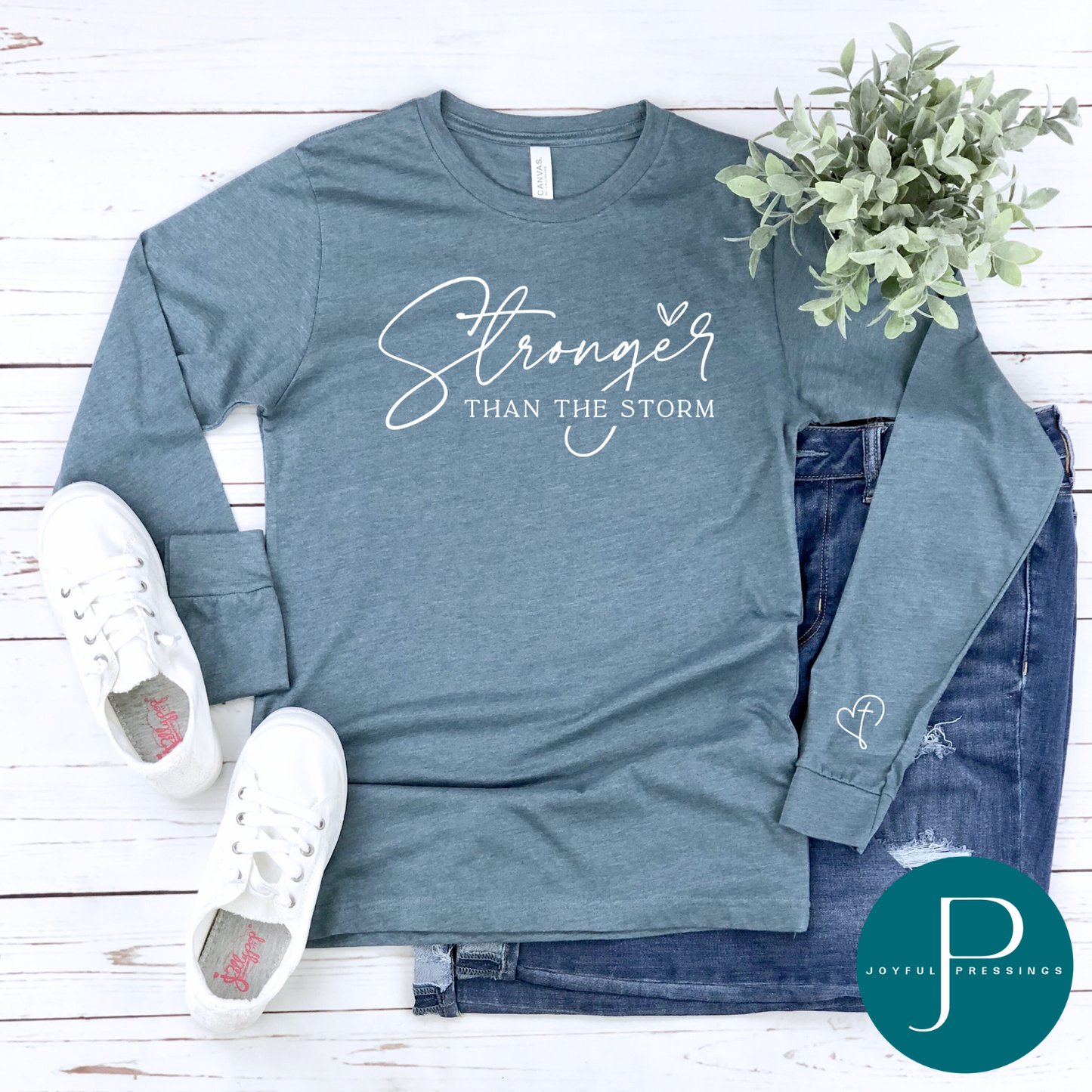flatlay of heather slate long sleeve tee with white stronger than the storm print