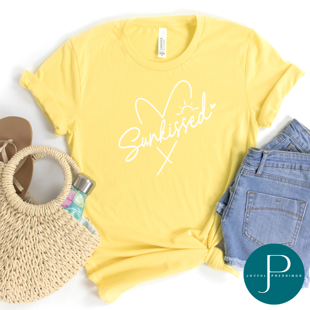 Sunkissed with a heart in white on a yellow tee.