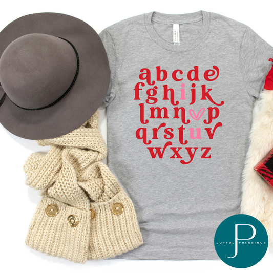 flatlay of athletic heather tea with red and pink alphabet print
