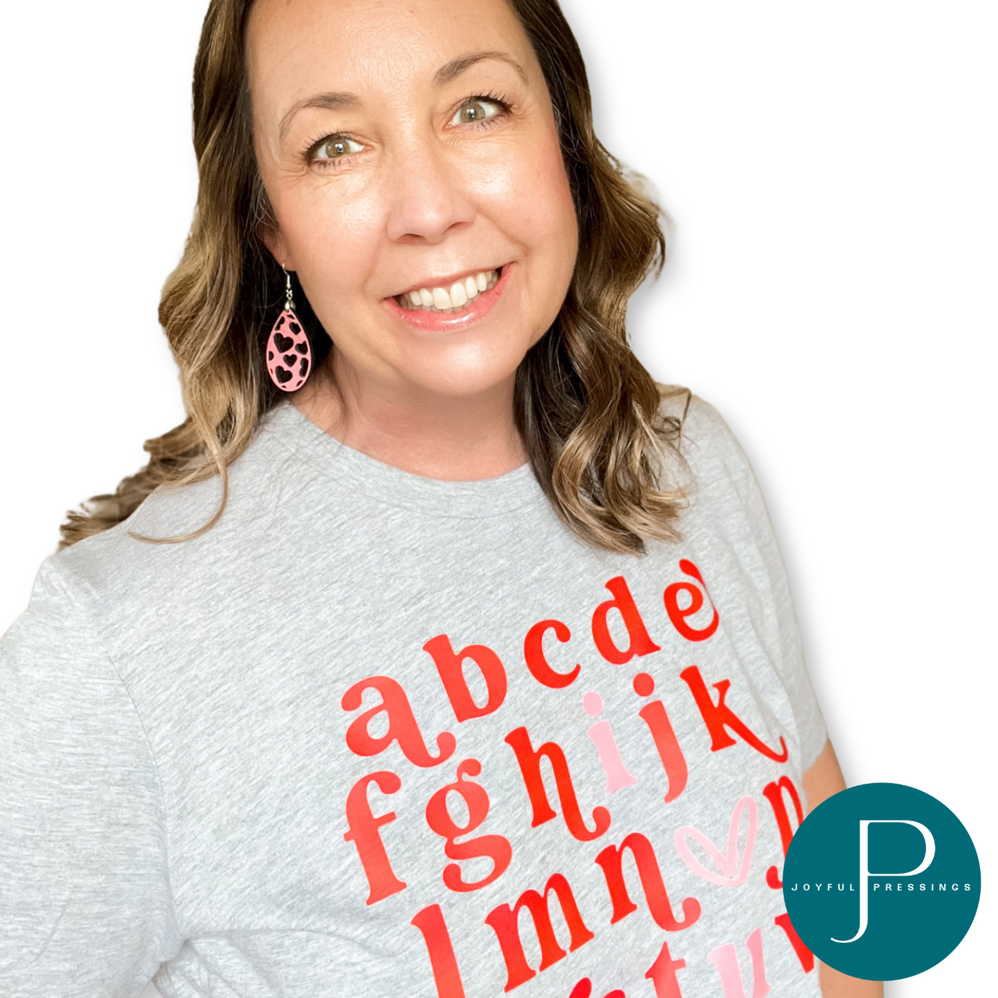 pink heart cutout teardrop earrings displayed on a model