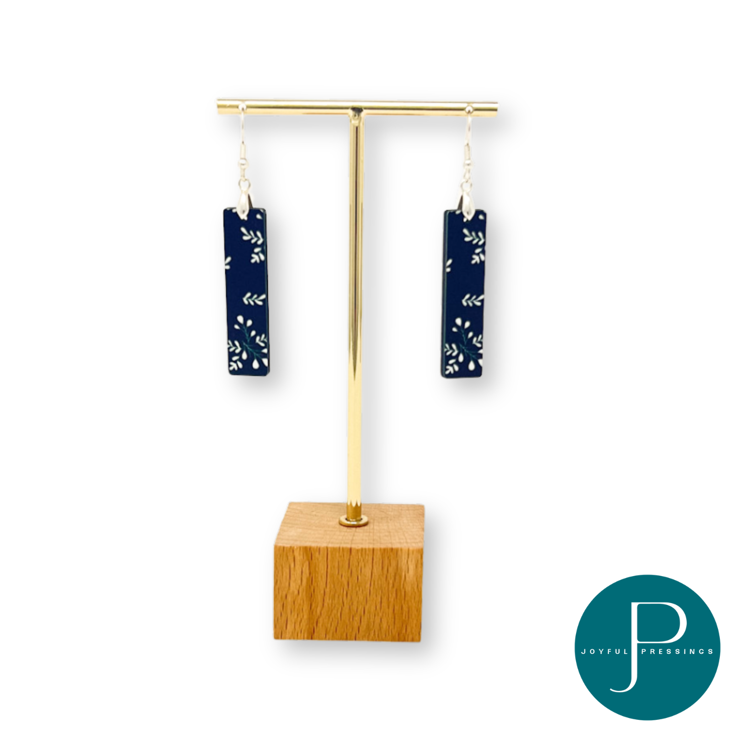 Black & white holly branch bar earrings on a display