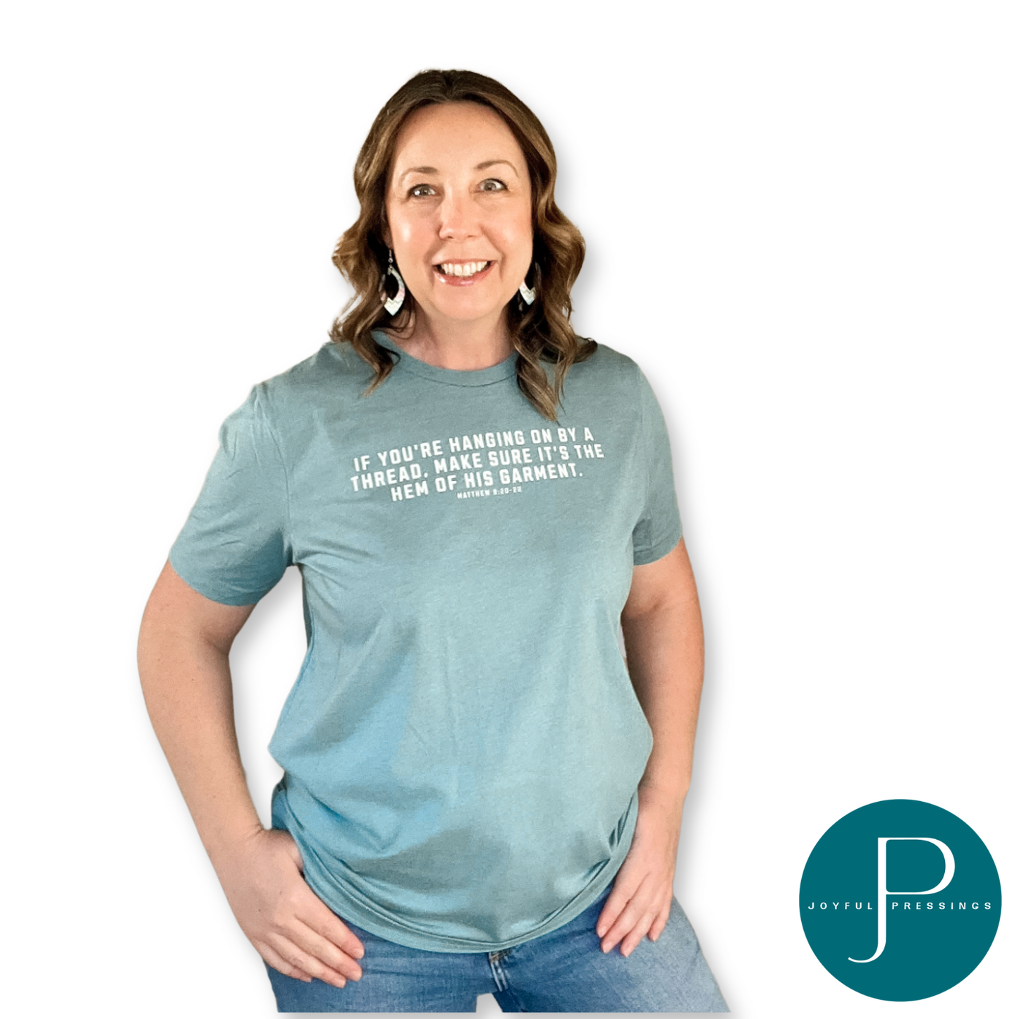 Model wearing Hanging on by a thread blue lagoon t-shirt with cream print.