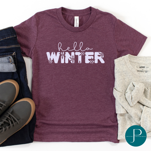 flatlay of lavender graphic that says hello winter on a heather maroon tee.