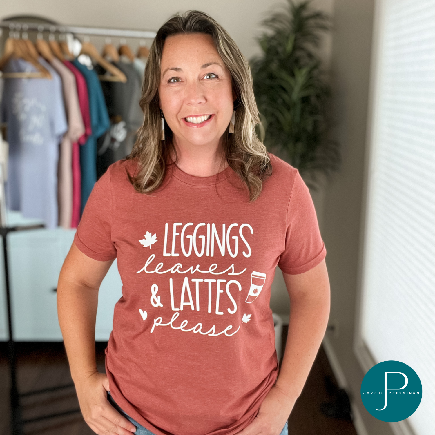Model wearing a heather clay t-shirt with the print Leggings Leaves & Lattes please in white.