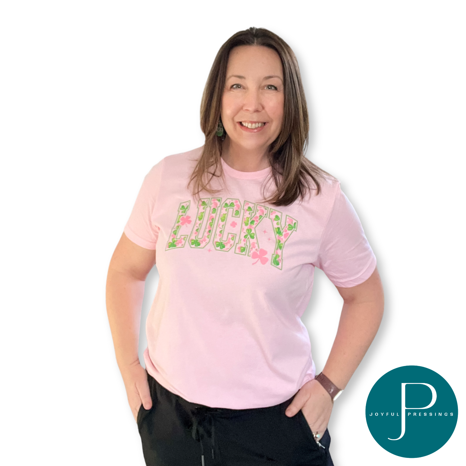 Woman wearing a pink t-shirt with lucky text and shamrock graphics, standing against a white background.
