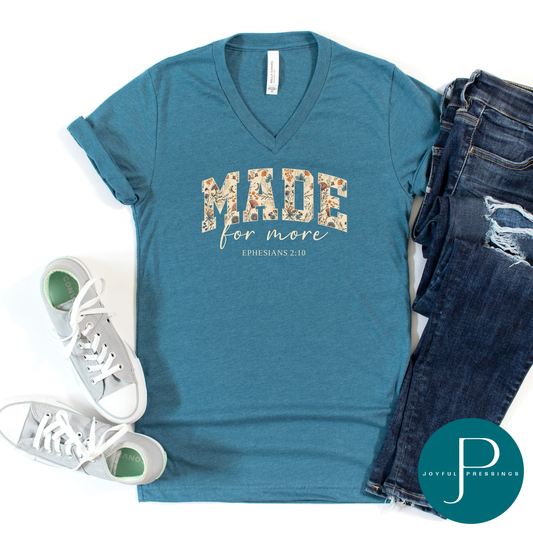 Blue t-shirt with 'Made for more' text, white sneakers, and jeans on a white background