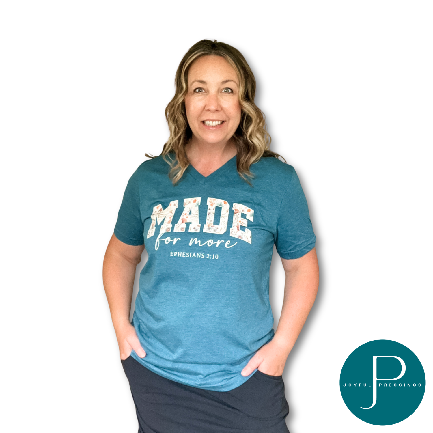 Woman wearing a deep teal t-shirt with 'MADE for more' text, standing against a white background.