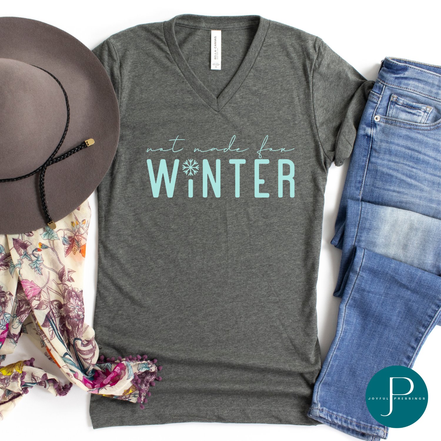 Flatlay of gray tee says Not Made for Winter in teal.