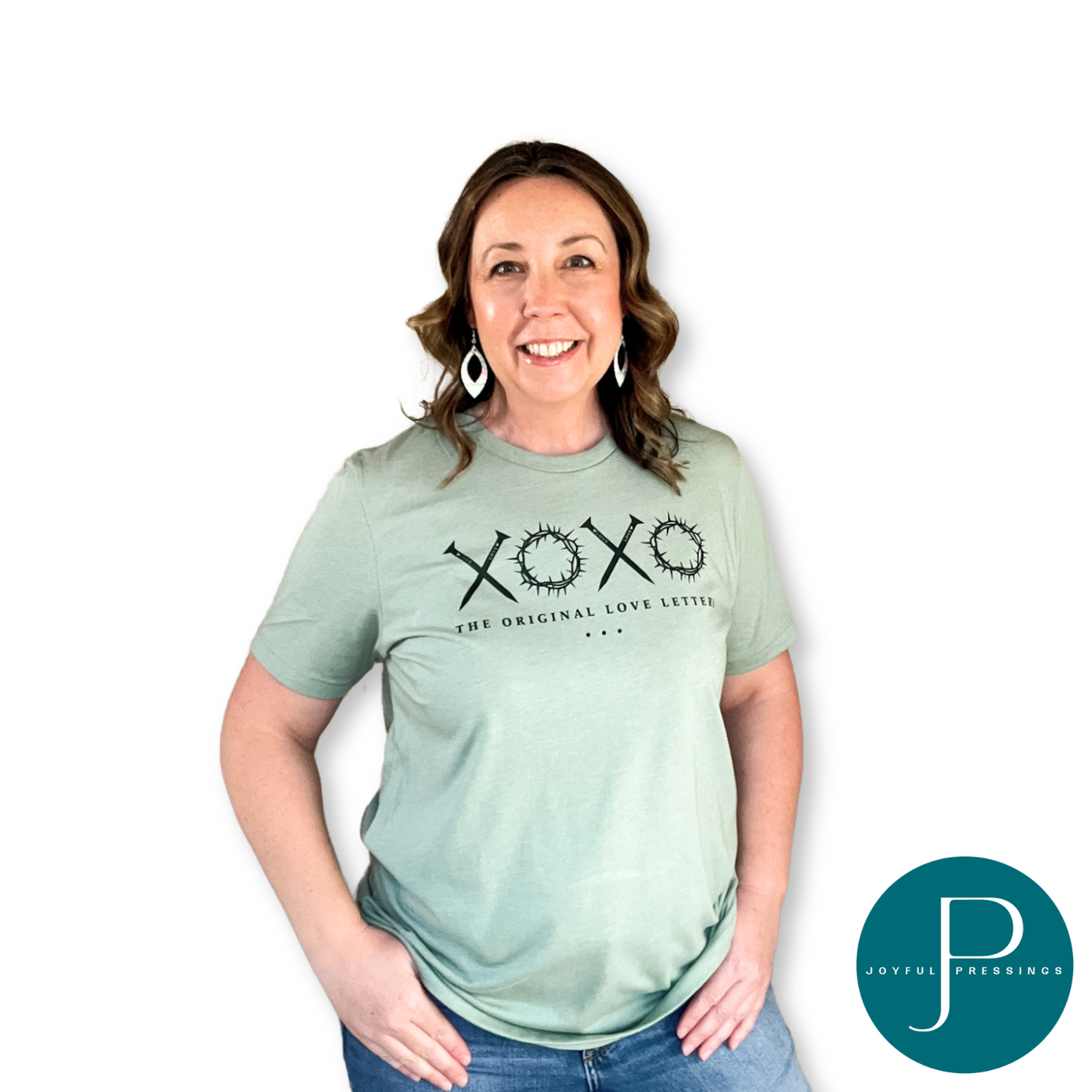 Model wearing The Original Love Letters sage green t-shirt.  Nails for the X's and crown of thorns form the O's in the XOXO print.