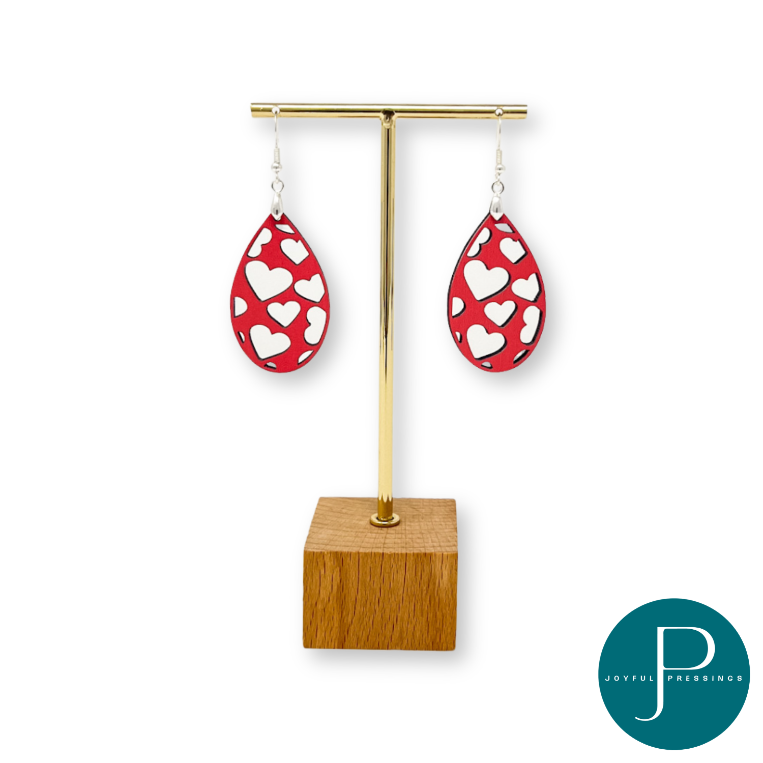 pink heart cutout teardrop earrings displayed on a stand