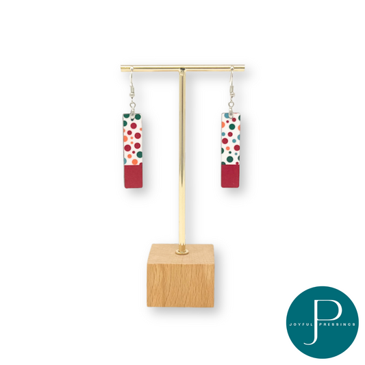 Red polka dot earings showcased on a stand