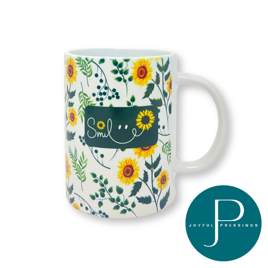 White ceramic mug decorated with vibrant sunflowers and greenery, featuring the word ‘Smile’ in playful script accented with sunflower details.